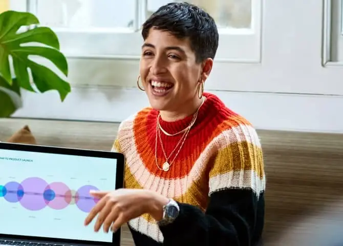 A woman pointing at a document on a laptop